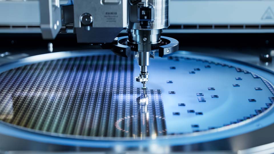 Precision equipment placing microchips onto a semiconductor wafer during fabrication.